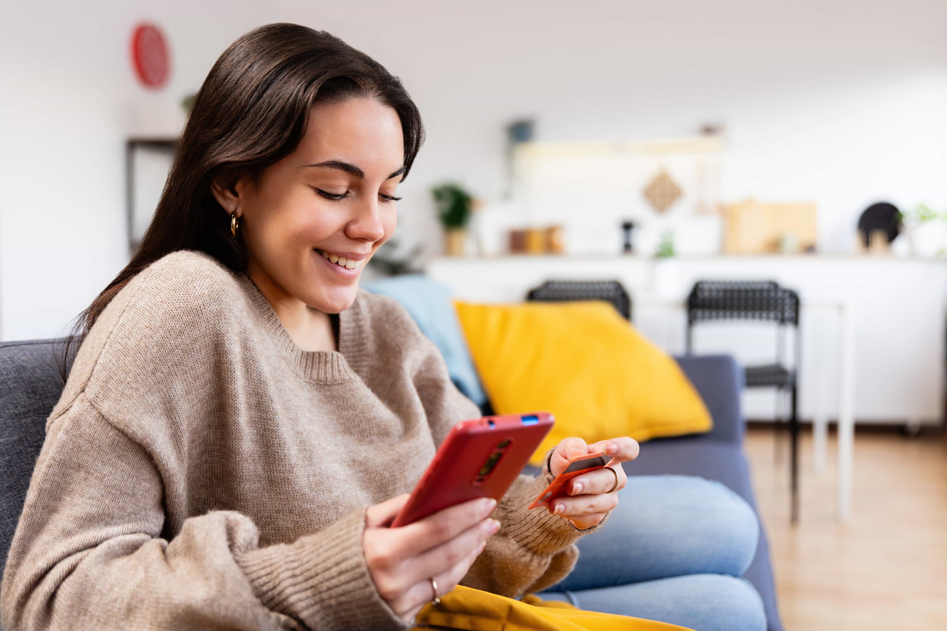 Junge Frau benutzt ETF Auszahlungsrechner auf ihrem Handy und lächelt